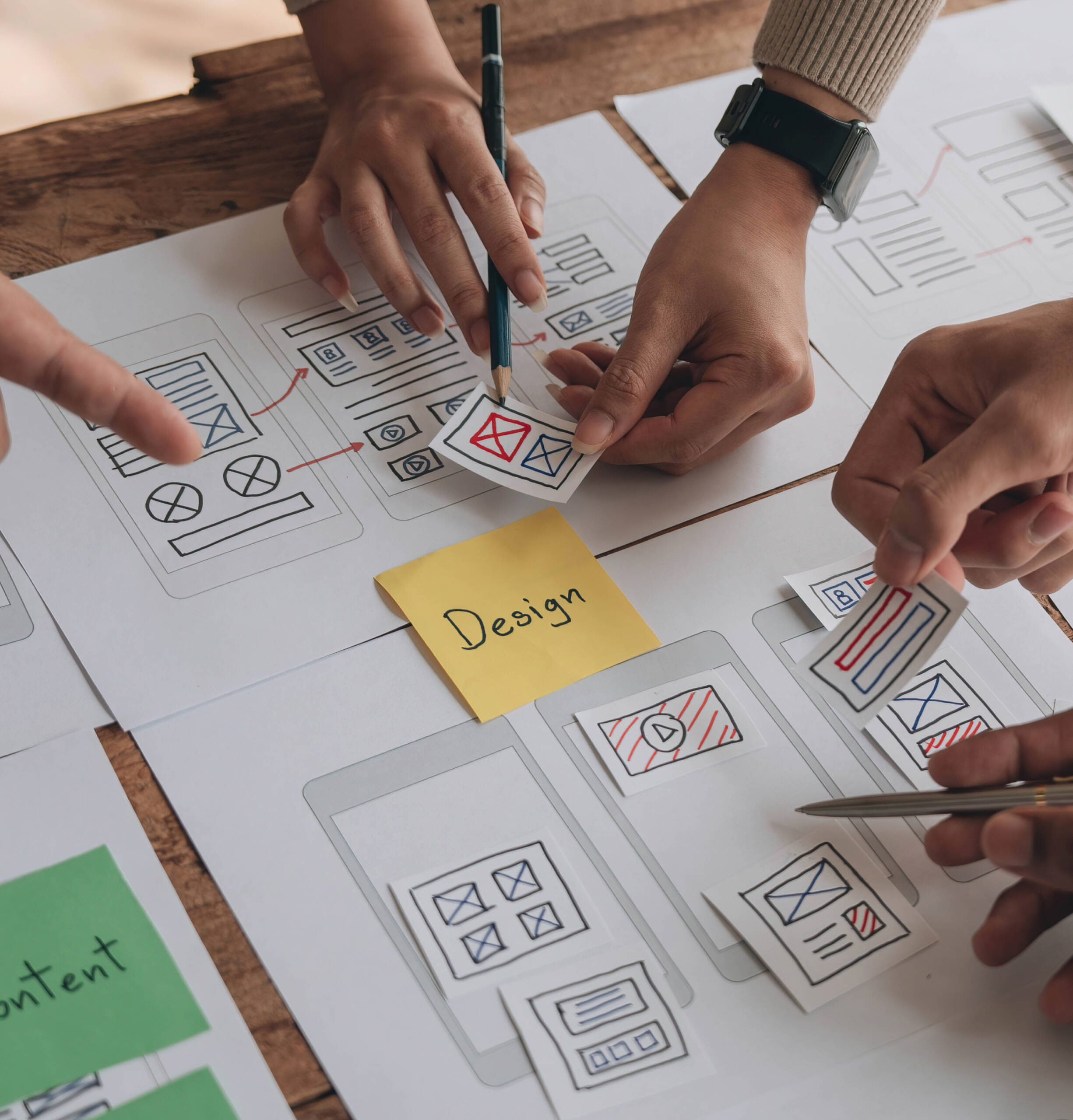 People discussing about the UX by placing paper card on the mobile wireframe screen