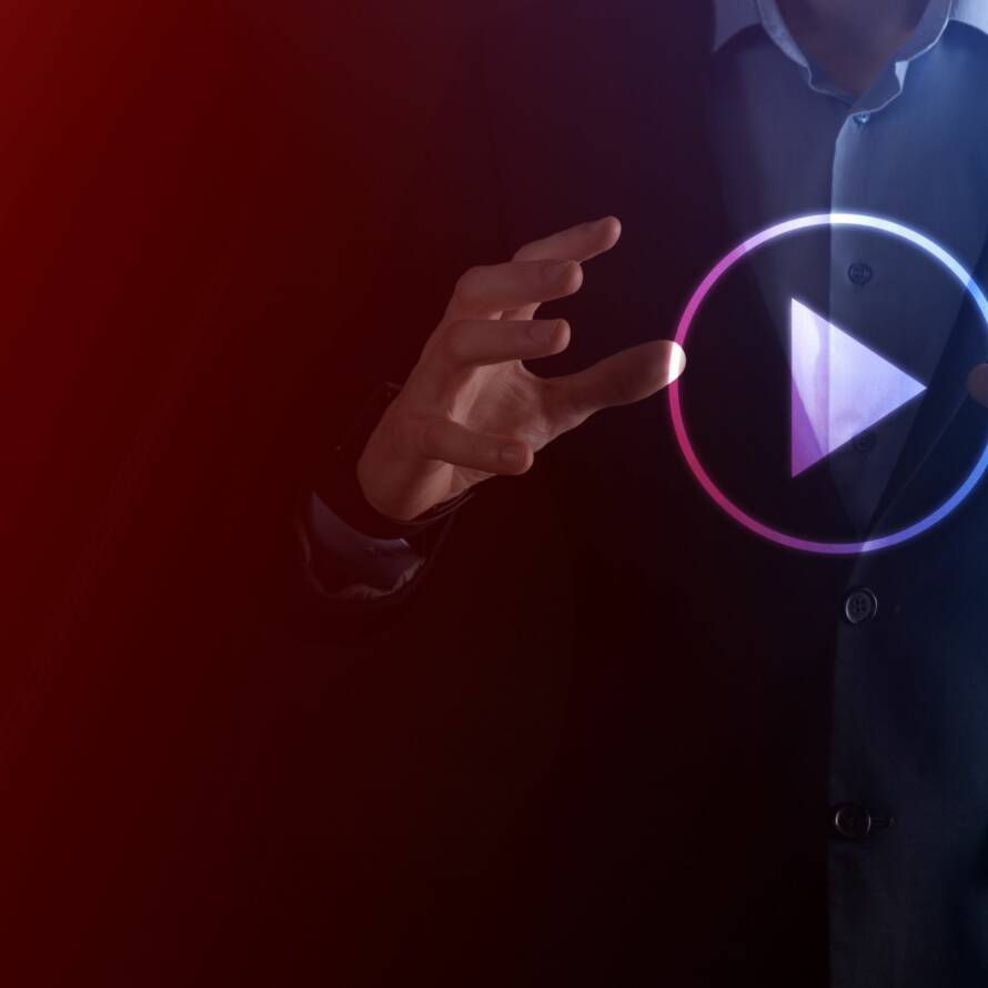A person in suit has his hands around a virtual video play button