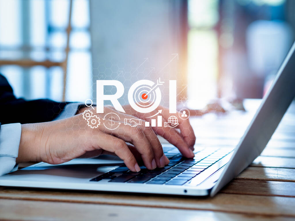 A professional calculating ROI of a design agency on a laptop