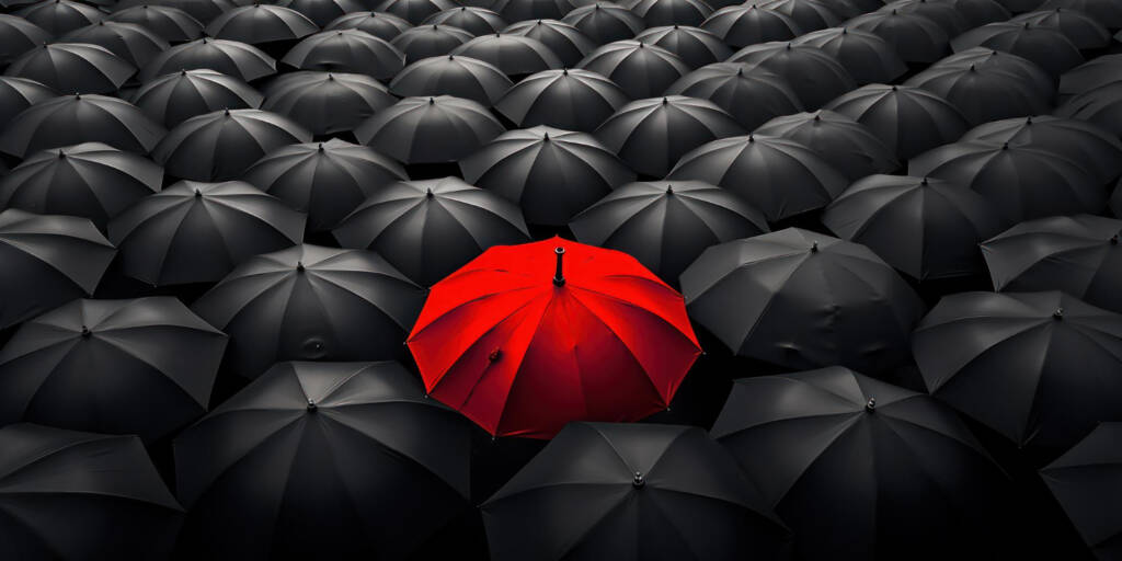 one red canopy shines among many grey umbrellas