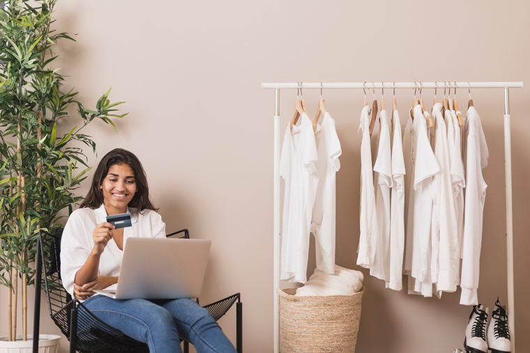 Lady looking at her credit card while online shopping