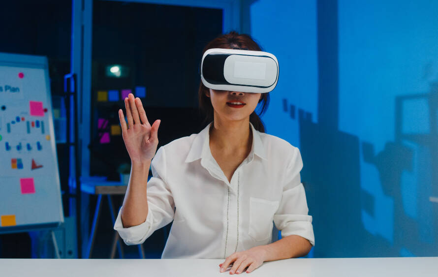 A woman wearing VR raising one hand