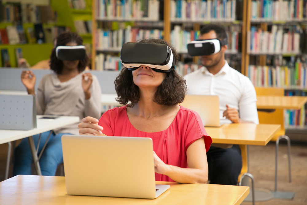 Women wearing VR set attending a lecture while sitting in the library.