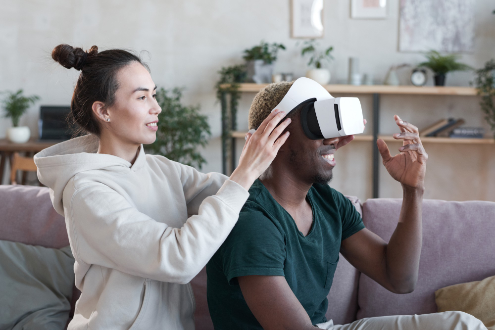 Woman putting the VR set on man on a sofa