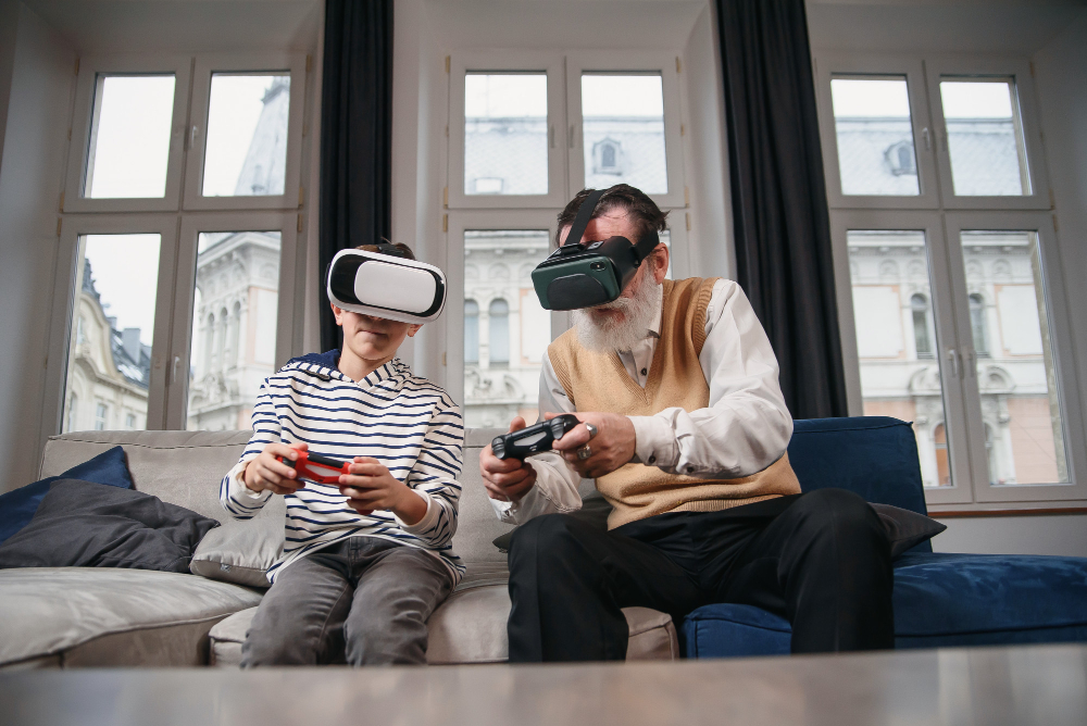 Elderly man and young boy wearing VR headsets, playing video games together on a couch in a modern living room.