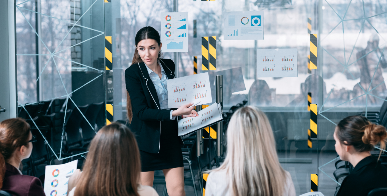 Lady presenting stats on paper to the rest of the group of ladies