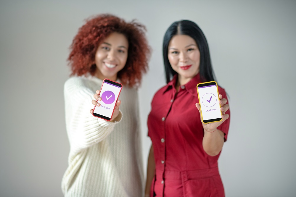 Friends holding smartphones while using social media