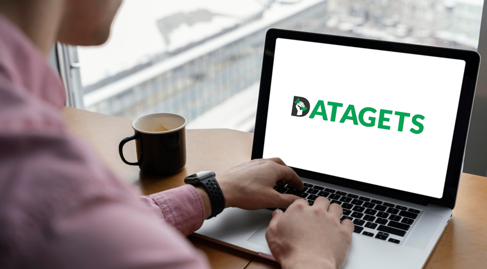 Man using laptop with Datagets logo displayed on screen